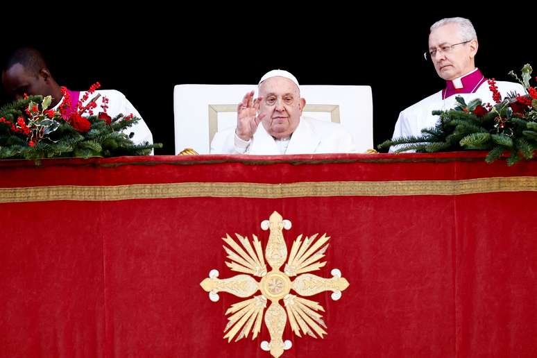 O Papa Francisco acena no dia em que faz seu tradicional discurso Urbi et Orbi de Natal para a cidade e o mundo na sacada principal da Bas&iacute;lica de S&atilde;o Pedro no Vaticano, em 25 de dezembro de 2024. 