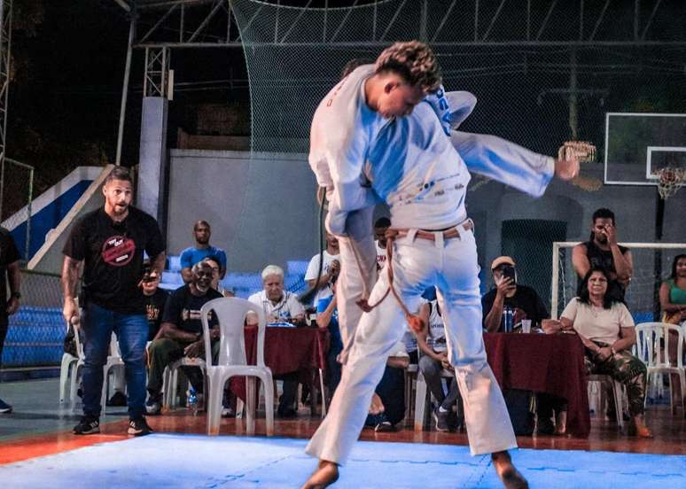 Faisquinha ergue no ar o oponente Boneco na final do reality de capoeira. Campeão não achava que fosse vencer.