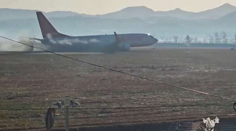 Fumaça preta sai de avião da Jeju Air durante o voo 7C2216, enquanto avião sai da pista de pouso antes de bater em muro no Aeroporto de Muan, Coreia do Sul, em imagem obtida de vídeo.