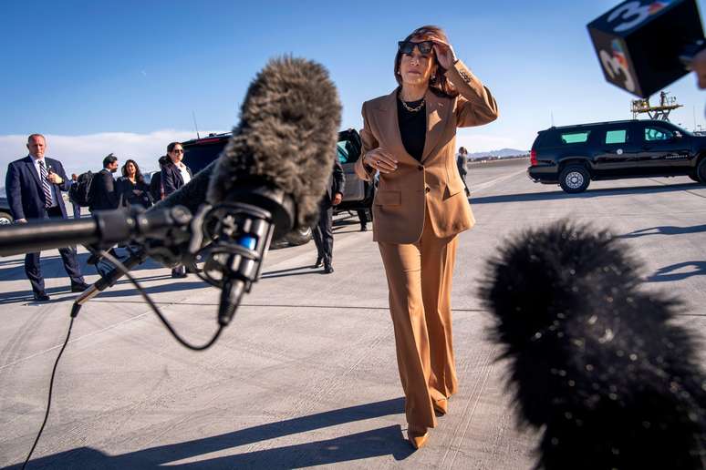 A então candidata presidencial democrata, a vice-presidente Kamala Harris, caminha em direção aos jornalistas antes de embarcar no Aeroporto Internacional de Las Vegas, em 10 de outubro de 2024, com destino ao Arizona