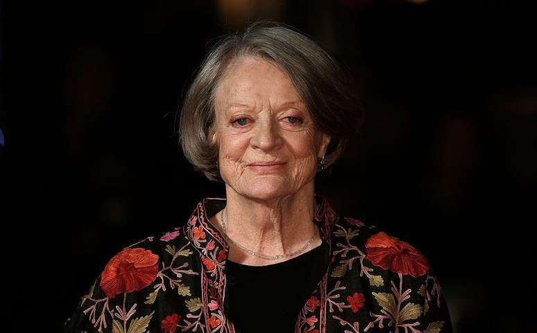 Dame Maggie Smith posa para retrato com roupa florida e fundo preto