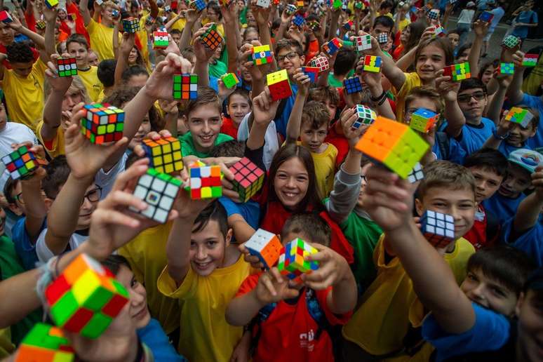 Estudantes em Budapeste, Hungria, comemoram o 50º aniversário da invenção do Cubo de Rubik; Crianças e adolescentes costumam ser maioria nas competições de cubo.