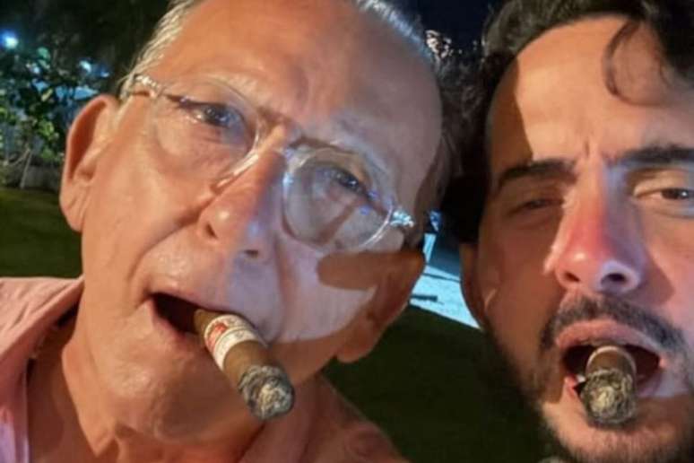 Galv&atilde;o Bueno fuma charuto ao lado de empres&aacute;rio durante comemora&ccedil;&atilde;o do ano-novo, em Pernambuco.