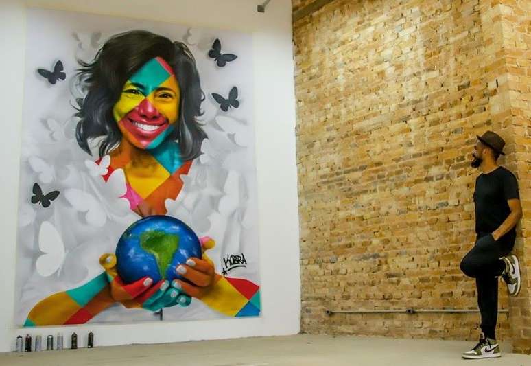 Eduardo Kobra ao lado do mural em homenagem a Glória Maria, mais uma personalidade retratada pelo artista.