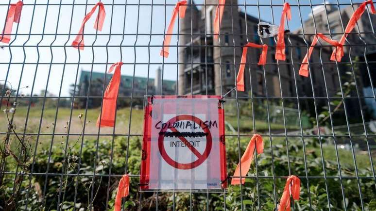 'Proibido o colonialismo', diz o cartaz na grade em frente ao antigo Royal Victoria Hospital de Montreal, durante um protesto para recordar as atrocidades cometidas por décadas no Canadá contra os povos originários