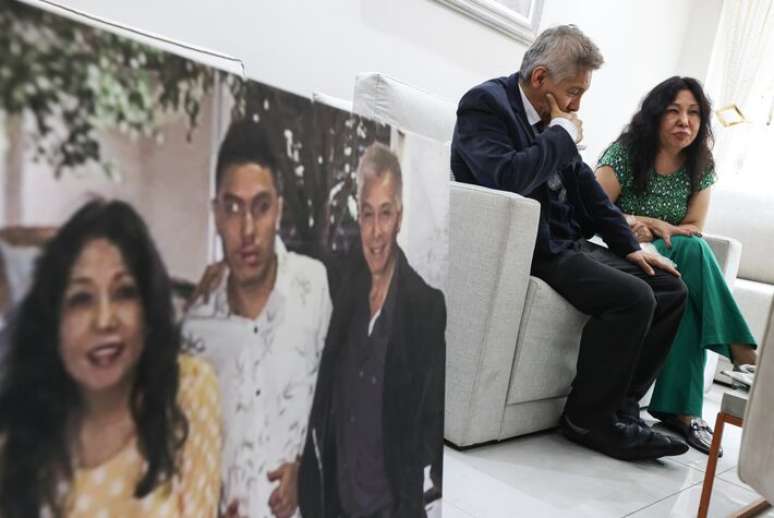 Julio Cesar Acosta Navarro e a mulher, Silvia, concedem entrevista ao lado de quadro com a foto do filho Marco Aurélio, estudante de medicina morto pela PM.