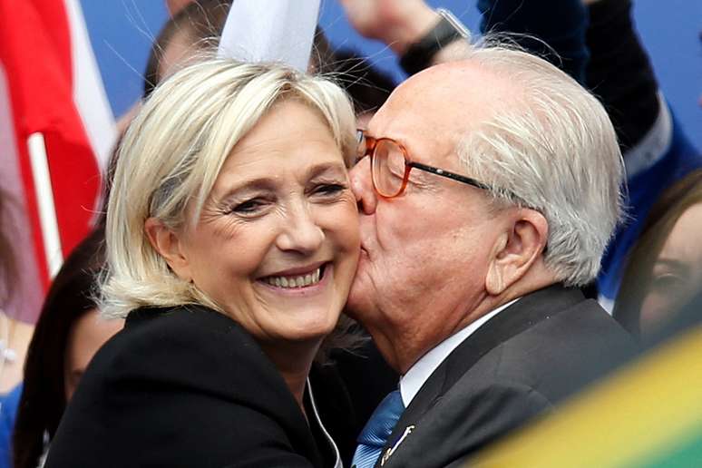 Jean-Marie Le Pen abra&ccedil;a sua filha Marine Le Pen ap&oacute;s seu discurso em seu tradicional com&iacute;cio em Paris, Fran&ccedil;a, em 1&ordm; de maio de 2013.