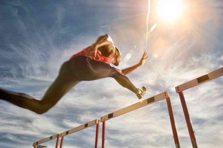 Atleta saltando sobre um obstáculo.