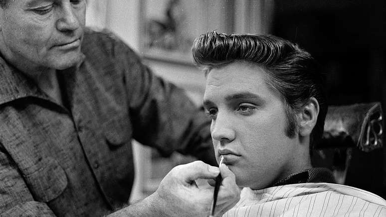 Uma maquiadora aplica um toque de batom em Elvis Presley