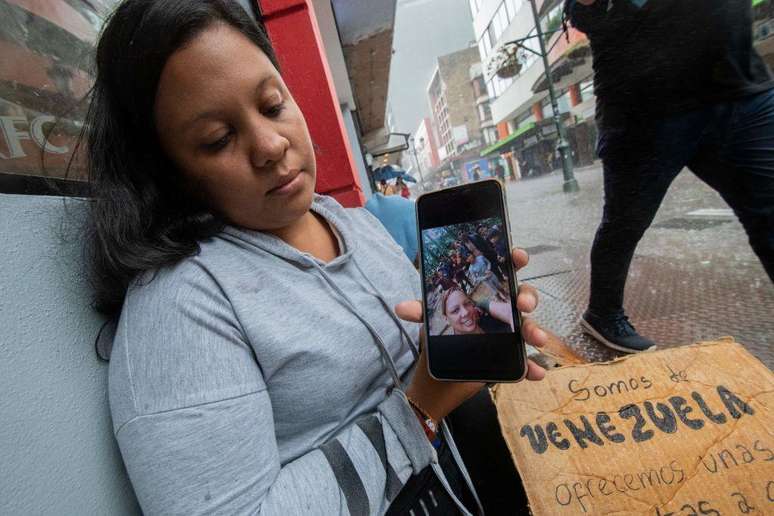 Migrante venezuelana mostra uma foto dela e de sua família enquanto cruzavam o Darién