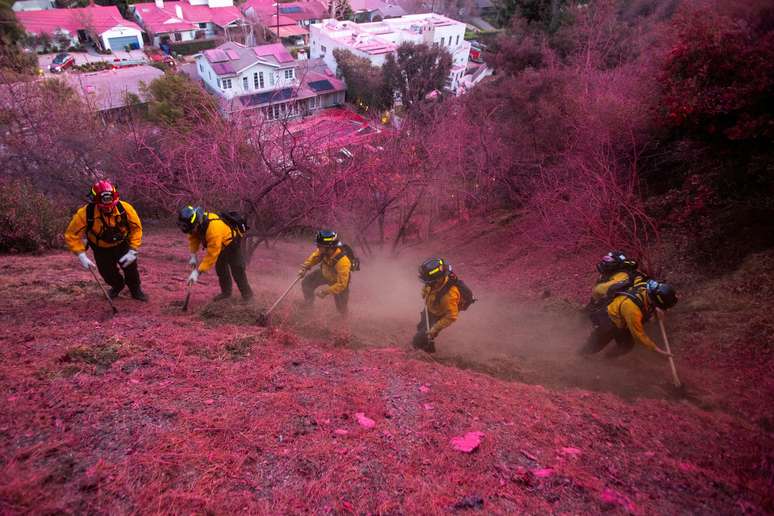 Bombeiros aplicam retardador de chamas rosa brilhante na vegetação em Los Angeles