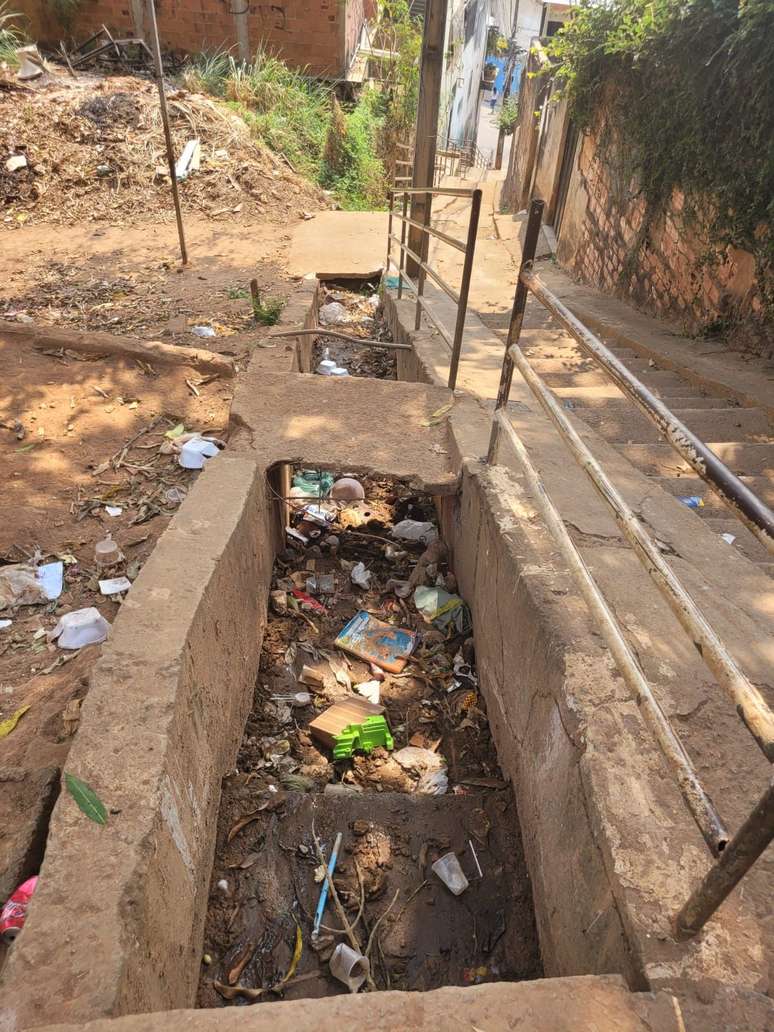 Uma das valas por onde deveria escoar a água no bairro Bethânia estava entupida de lixo antes da chuva.