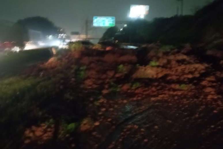 Equipes trabalham no local para tirar terra da pista e liberar o fluxo de veículos