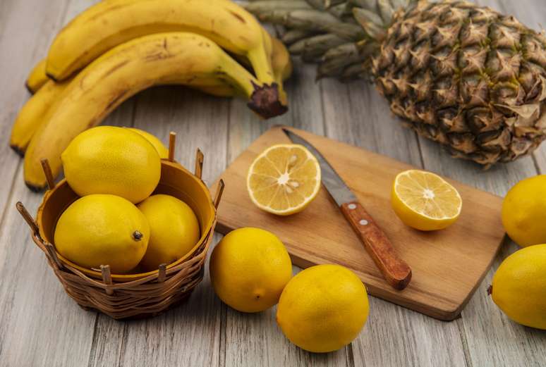 Abacaxi, banana e limão na mesa.