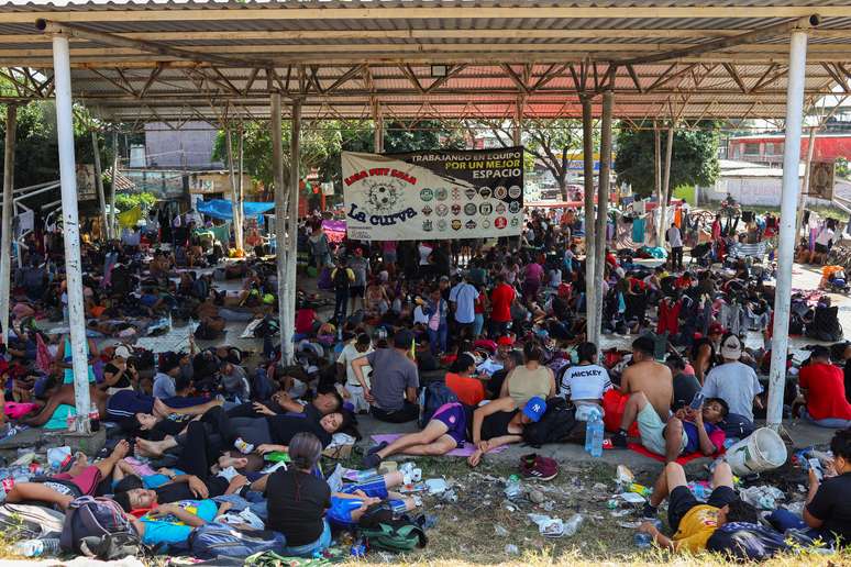 Migrantes aguardam em uma quadra de esportes por caravana com destino à fronteira norte entre Estados Unidos e México, na cidade de Huixtla