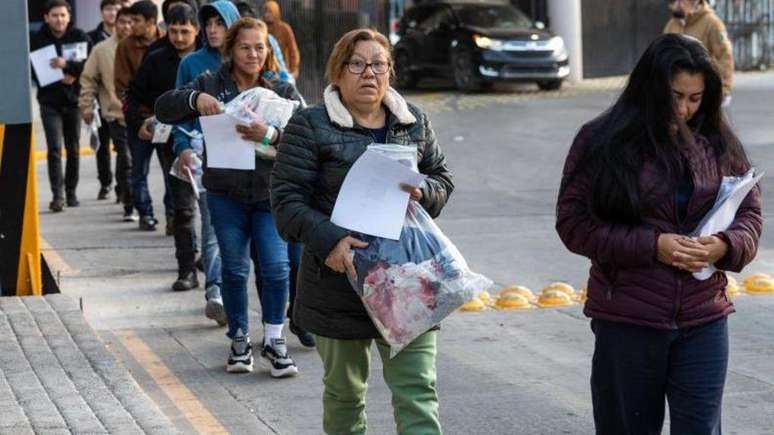 Fila de pessoas para deportação na fronteira, em 21 de Janeiro, após posse de Trump, que prometeu deportação em massa