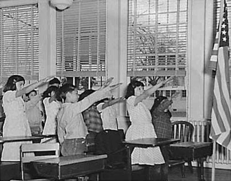 Crianças de escola dos EUA fazendo a saudação de Bellamy à bandeira dos Estados Unidos, 1941.