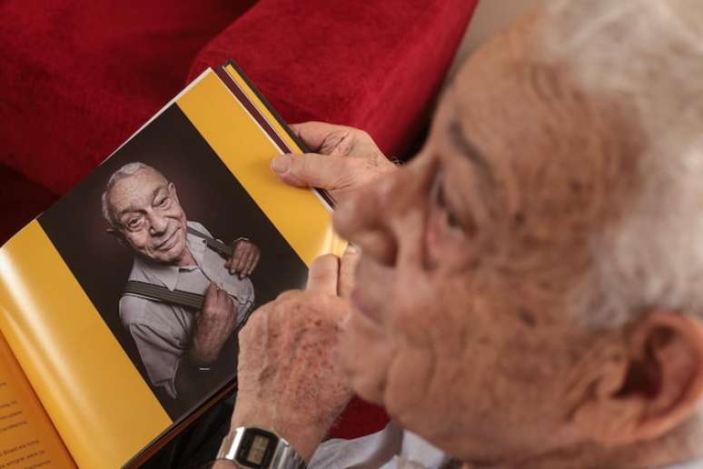 Stefan Lippmann, de 89 anos, mostra uma foto de um livro que contou com seu depoimento