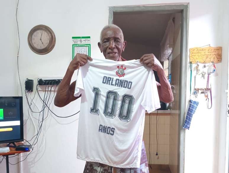 Orlando de Souza em casa com a camiseta corintiana feita por parentes em homenagem aos 100 anos.