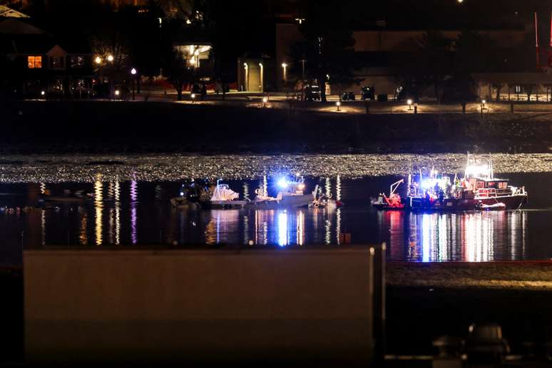 Equipe de emerg&ecirc;ncia e mergulhadores trabalham perto de partes dos destro&ccedil;os do voo 5342 da American Eagle, depois que ele colidiu com um helic&oacute;ptero Black Hawk ao se aproximar do Aeroporto Nacional Reagan Washington e caiu no Rio Potomac, fora de Washington, EUA, 30 de janeiro de 2025. 
