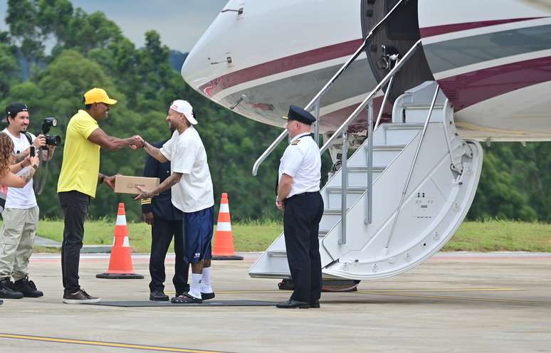 Neymar recebe presente ao desembarcar no Brasil em seu retorno ao futebol brasileiro.