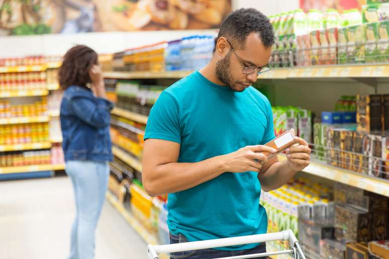 Homem comprando suco em caixa