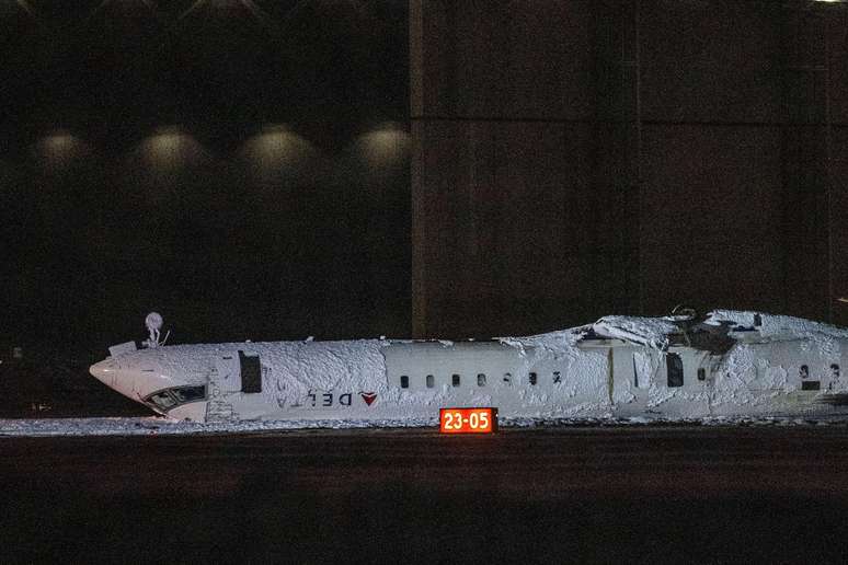 Foto noturna mostra avião de ponta a cabeça com neve