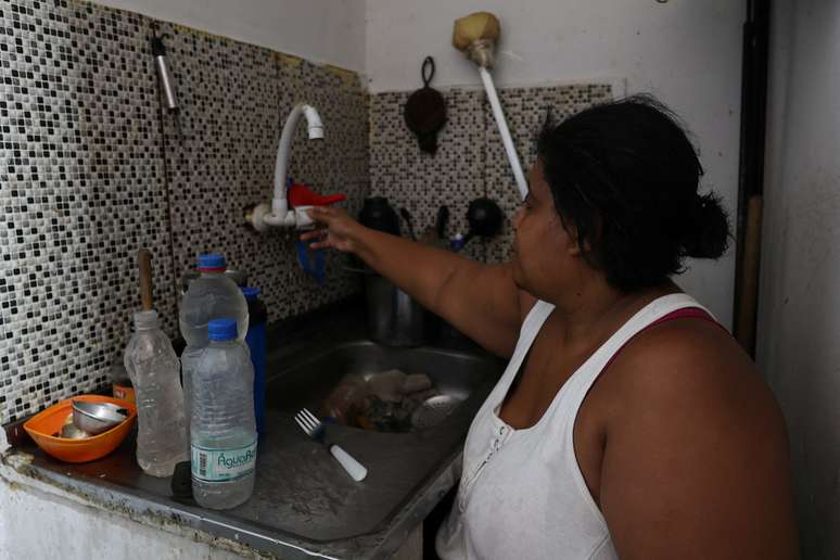 Dayana da Silva, 38, mostra que est&aacute; sem &aacute;gua em casa em meio a uma onda de calor extremo na favela do Jacarezinho, no Rio de Janeiro, Brasil, em 18 de fevereiro de 2025.