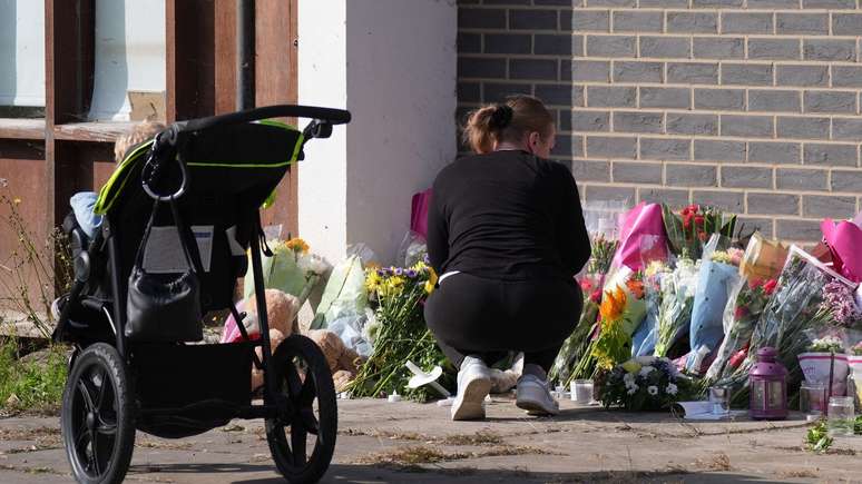 Tributes in the form of the flowers were left on the scene after the discovery of his mother's mother's bodies, brother and sister Tributes in the form of the flowers were left on the scene after the discovery of his mother's mother's bodies, brother and sister