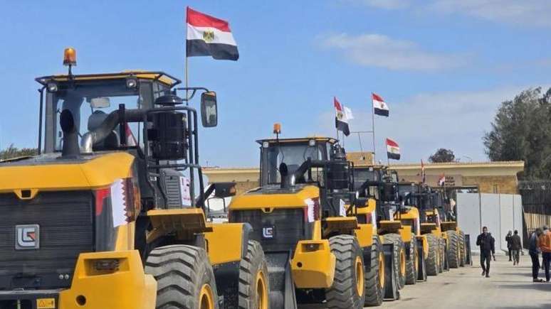 Caminhões transportando equipamento pesado de construção enviados do Egito para Gaza aguardam no lado egípcio da fronteira