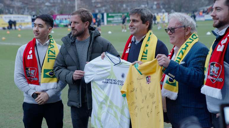 Dirigentes do clube, com cachecol que mistura as cores do Exeter e do Brasil, trocam camisas em dia de celebra&ccedil;&atilde;o da hist&oacute;ria do clube que enfrentou a sele&ccedil;&atilde;o em 1914