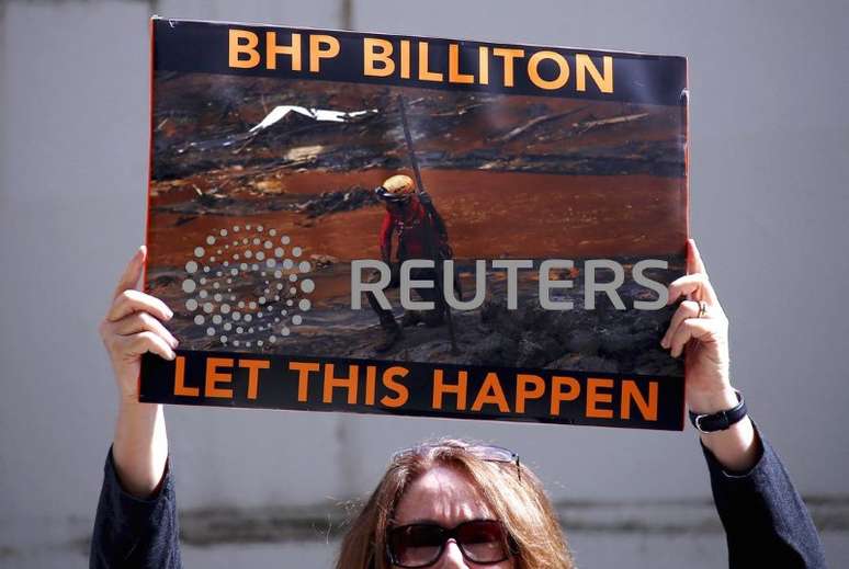 Manifestante segura cartaz em protesto sobre o rompimento de barragem da Samarco ao lado de fora de assembleia geral anual da empresa de mineração BHP em Perth, Austrália Ocidental
19/11/2015
REUTERS/David Gray