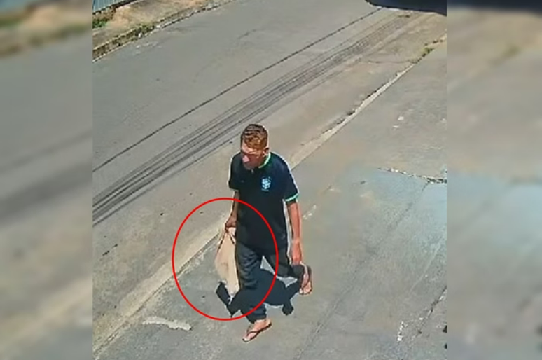 Homem carrega animal morto em saco