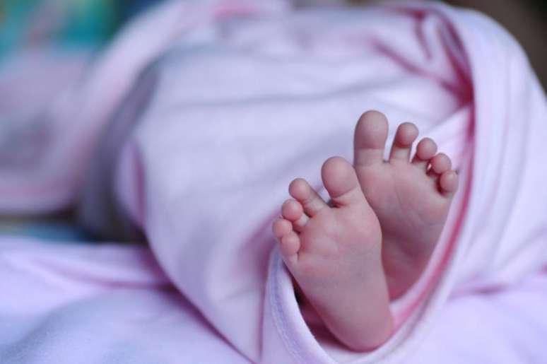 Imagem mostra pés de bebê menina.