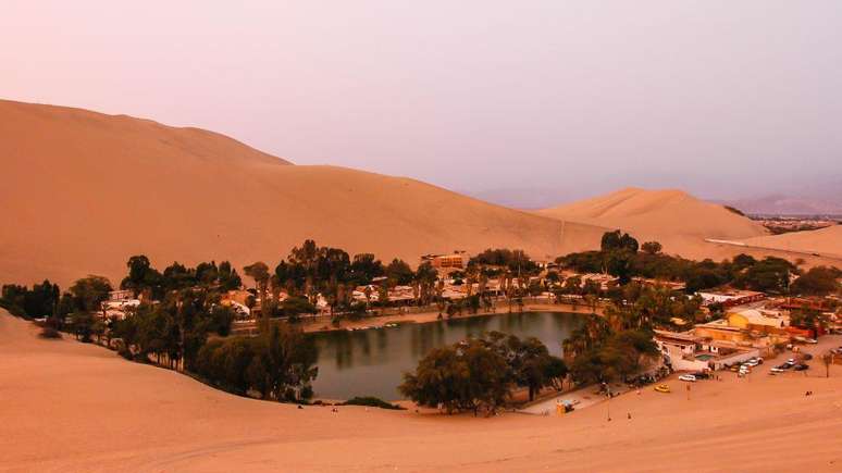 O&aacute;sis de Huacachina &eacute; cercado por &aacute;rvores e casas
