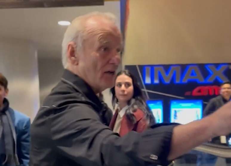 F&atilde; parece se esbarrar no ator enquanto tenta gravar imagens