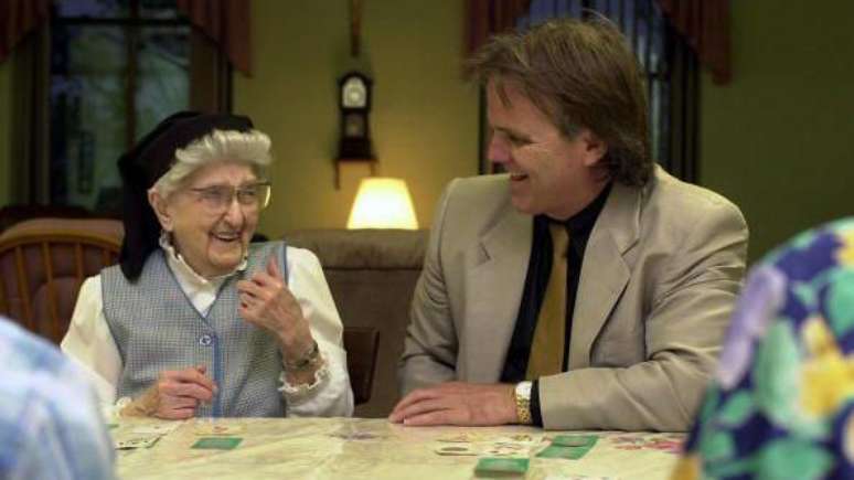 Em foto de 2001, a irm&atilde; Esther, de 106 anos, ri ao lado de David Snowdon, durante um jogo de cartas no convento das Irm&atilde;s Escolares de Nossa Senhora