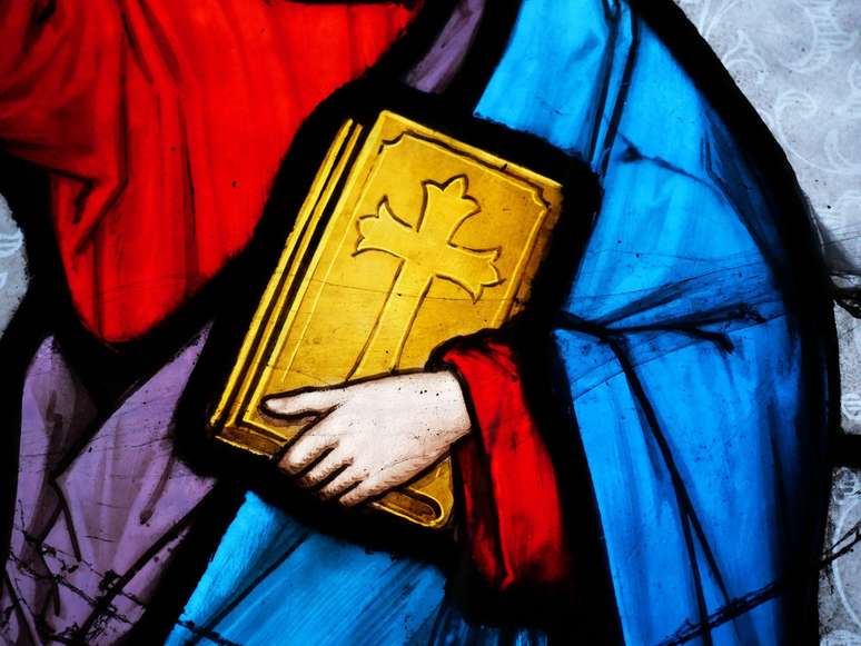 M&atilde;o segura B&iacute;blia em vitral