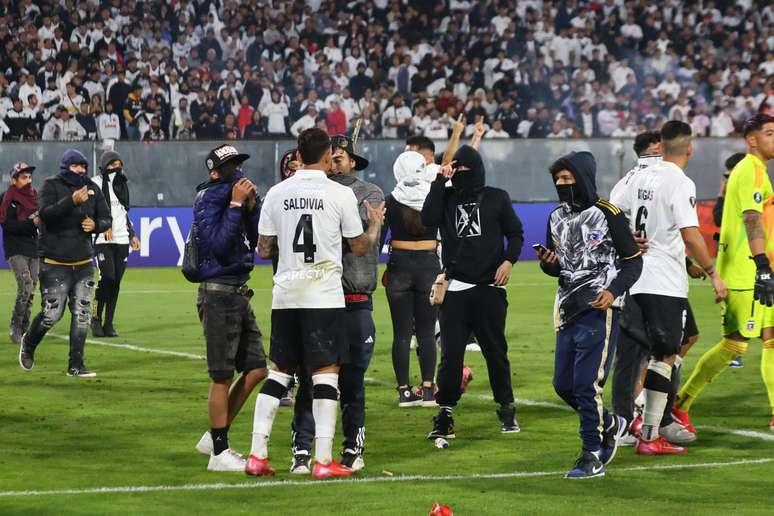 Jogadores do Colo Colo conversam com torcedores que invadiram o gramado