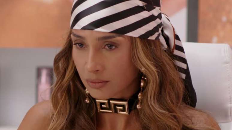 A personagem Lola, de 'Beleza Fatal', usando lenço
