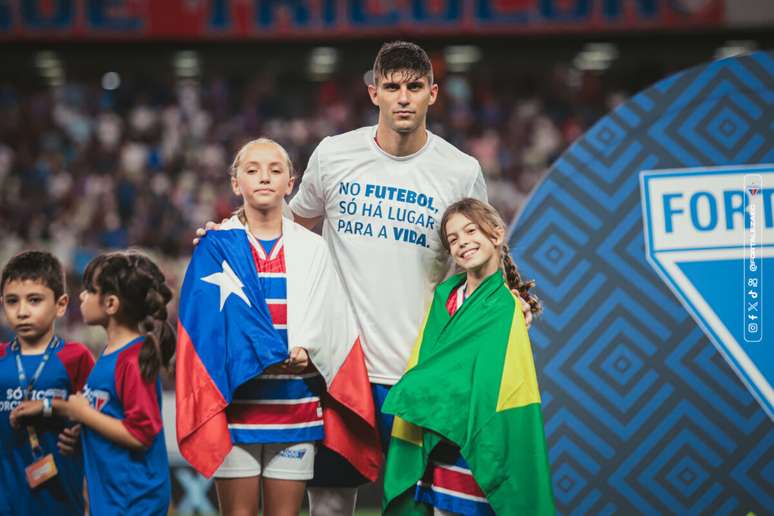 Kuscevic e as crianças com as bandeiras de Chile e BrasiL. 