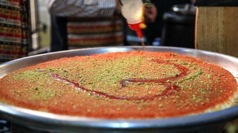 Knafeh &eacute; uma sobremesa popular em pa&iacute;ses como Egito e Turquia, e &eacute; feita com uma massa folhada, queijo doce e pistaches