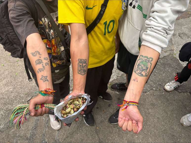 Torcedores do Atlético Nacional mostram pulseiras, balas e tatuagens do clube
