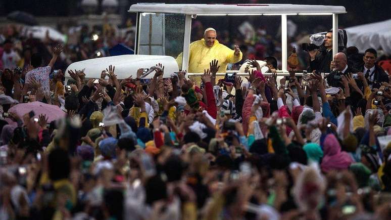 De capa de chuva amarela, papa Francisco acena para a multid&atilde;o em Manila durante uma visita &agrave;s Filipinas