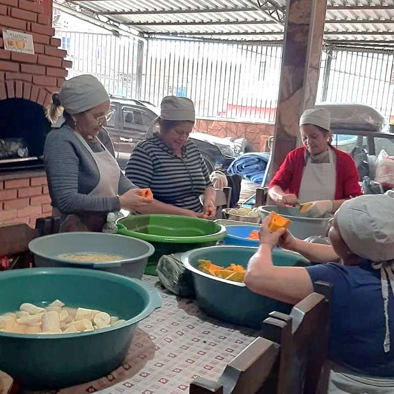 Voluntárias do projeto social Formiguinhas do Amor preparando alimentos na garagem da vovó Luceli, em Cidade Tiradentes.