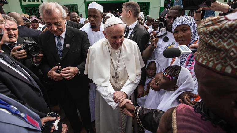 Papa Francisco cumprimentando crian&ccedil;as com a imprensa em volta