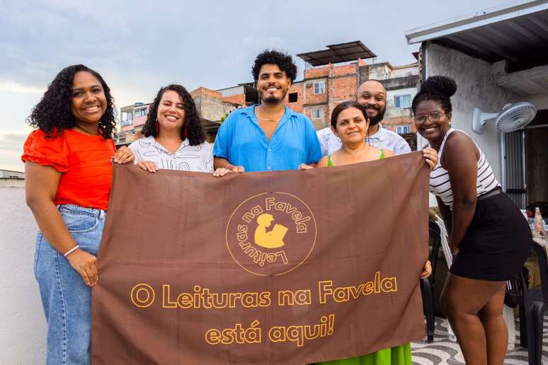 No centro da foto, de branco e azul, Camila Mendes e Anderson Oli, crias e criadores do projeto de leitura na Maré (RJ).