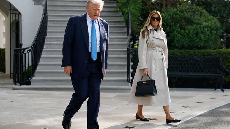 Melania Trump usando casaco de grife ao lado do marido