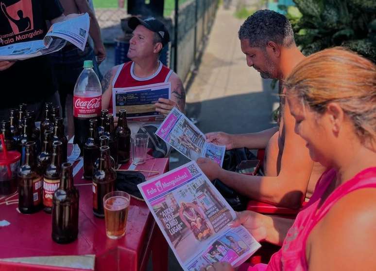 Jornal Fala Manguinhos, feito por jovens da comunidade, distribuído gratuitamente na feira. Iniciativa surgiu por mobilização social.