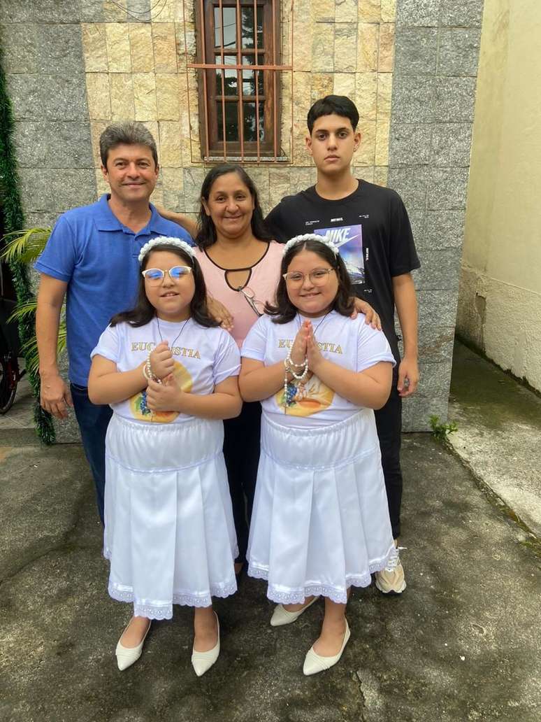As gêmeas Yasmin e Sophia, abençoadas pelo papa Francisco, na primeira comunhão, com pais e irmão. Católicos praticantes.